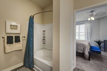 a bathroom with a shower and a bedroom with a bed  at Watermark on Twenty Mile, Parker